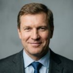 Профессиональный портрет русского бизнесмена, уверенный взгляд, студийное освещение, высокое качество.