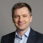 Портрет уверенного специалиста компании Автомаг по ремонту компрессоров автомобильных кондиционеров на нейтральном фоне